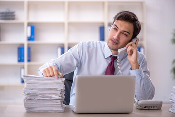 Fototapeta premium Young male employee and too much work in the office