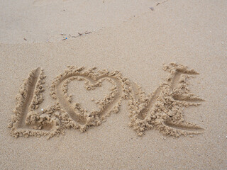 Word love in the sand at the beach.