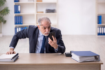 Old male employee working in the office