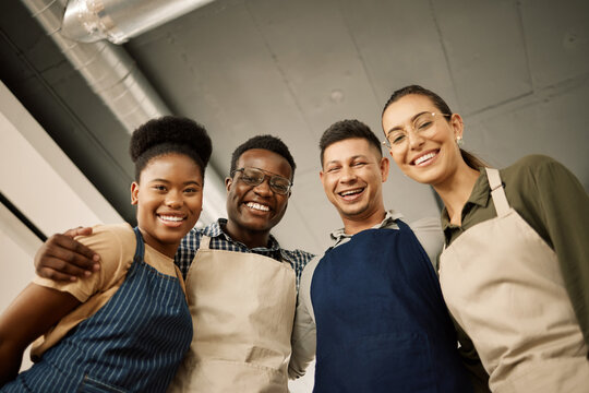 Group of diverse fashion designers hugging. Portrait of happy businesspeople together. Tailors relaxing in their design studio together. Creative colleagues hug one another at work