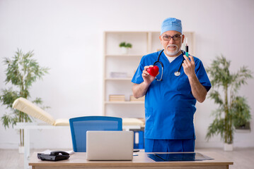 Old male doctor cardiologist working in the clinic