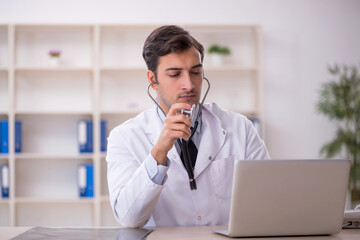 Fototapeta premium Young male doctor in telemedicine concept