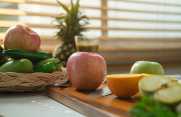 Healthy eating, dieting and weigh loss concept. Chopped orange and fresh red apple on cutting board .