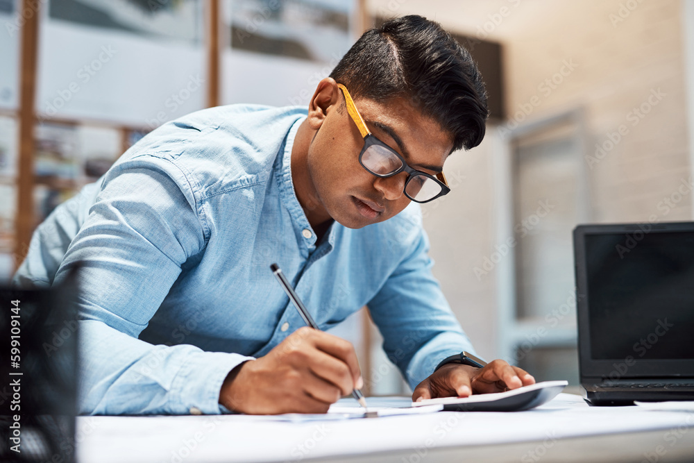 Aufkleber Success is starting to add up. a young architect using a calculator while drawing up a building plan.