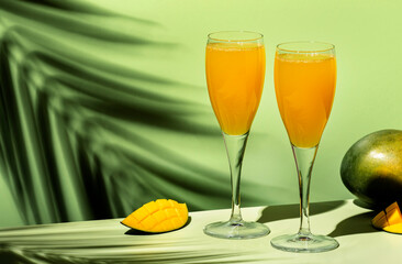 Mango bellini alcoholic cocktail with prosecco or sparkling wine, mango puree, syrup and ice. Light green background, hard light, shadow pattern