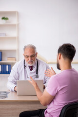 Young male patient visiting old male doctor