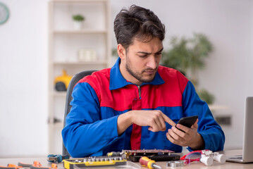 Young male repairman repairing computer