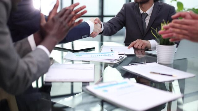 Business handshake between colleagues. close-up. Inside is a modern bright office.