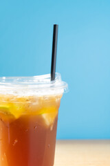 side view cup of iced lemon with straw vertical composition