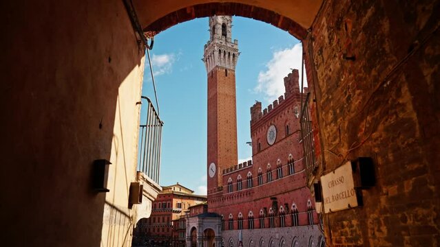 Walking towards the Piazza del Campo with the Tower of Mangia in the background, Siena, Italy. Hand held
