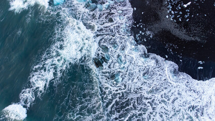 Melting Arctic Ice in Ocean Water, Blue Glacier Ice with Snow on Black Volcanic Beach in Iceland. Climate Crisis