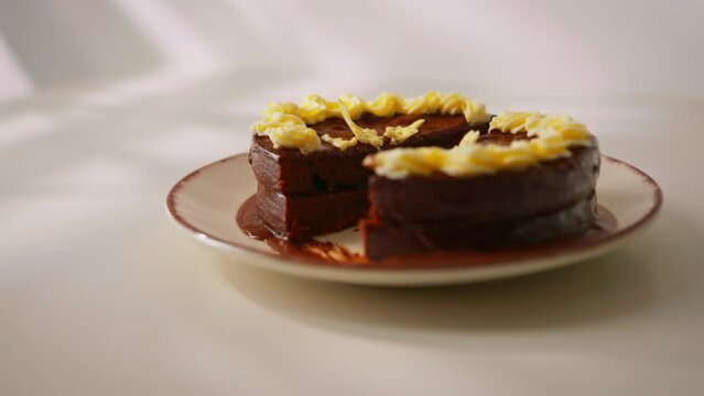 delicious chocolate cake Sacher or Prague cake on a white background dessert decorated with custard cut with a knife