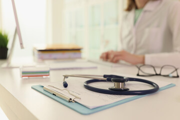 Stethoscope lies on clipboard with treatment plan on table