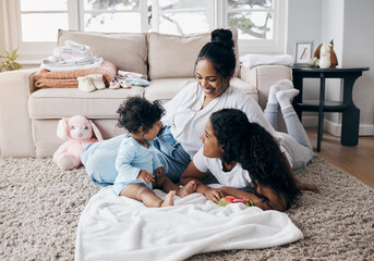 We make time for family. Full length shot of an attractive young woman sitting on the living room floor and bonding with her children.