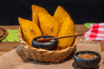 Colombian empanadas. Table with traditional Colombian food, wicker basket with empanada con aji, on...