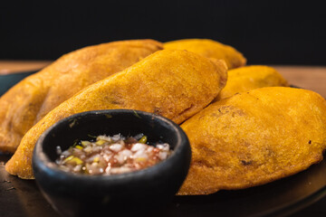 close up dish with empanadas with chili pepper on a table. Colombian traditional food. wood...