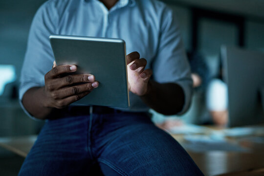 Smart apps keep things streamlined and efficient. an unrecognisable businessman using a digital tablet during a late night at work.