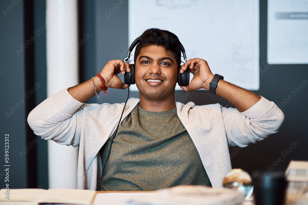 Poster music on, time to make design magic. portrait of a young architect using headphones while working in