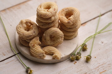 Cheese cookies on a white wooden table. Cookies are dry bread baked in the oven, made from wheat flour, eggs, sugar, cheese and other ingredients. White cheese cookie. sagu keju. sagoo cheese.