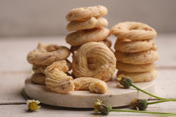 Cheese cookies on a white wooden table. Cookies are dry bread baked in the oven, made from wheat flour, eggs, sugar, cheese and other ingredients. White cheese cookie. sagu keju. sagoo cheese.