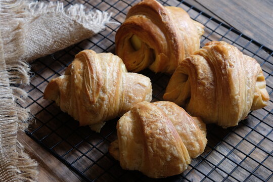 croissants on a cooling rack. croissant, which originated in France, is so named because of its shape resembling a crescent moon. made from wheat, eggs, salt, margarine. Cheese croissants. 