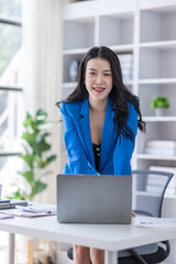 Portrait of Happy Excited young asian woman at workplace office desk, successful Asian female reading good news technology online, employee freelance finance concepts.	