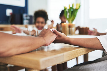 A family that prays together, stays together. an unrecognizable family holding hands during prayer time at home.