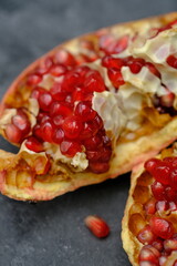 pomegranates are a staple of the diet. red pomegranate on a black table