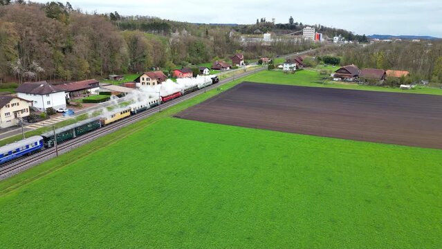 The steam locomotive Eb 3 5 5810 in Lyss as Whiskey Train with 11 waggons in the Seeland Region in Switzerland by Air