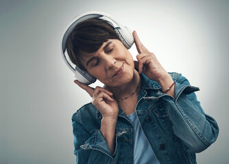 Music is the medicine of the mind. Studio shot of a senior woman wearing headphones against a grey background.