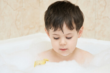 beautiful young boy playing in the bath tub