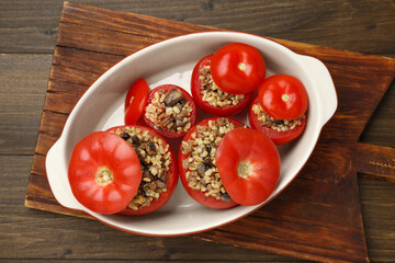 Delicious stuffed tomatoes with minced beef, bulgur and mushrooms on wooden table, top view