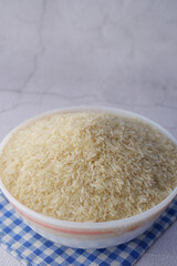 white long rice in a bowl on wooden background 