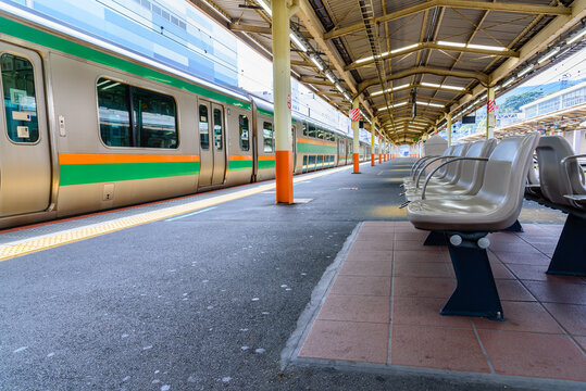 Chairs for passenger waiting area at railway station platform. Public transportation by train concept image.
