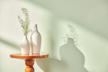 Vases and objects on the table in a warm room with sunlight coming in