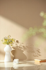 Vases and objects on the table in a warm room with sunlight coming in