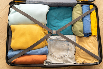 Top down view of an open suitcase prepared for travel. Neatly folded clothing for the vacation trip. Excited state before the trip