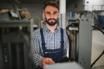 Happy Professional Heavy Industry Engineer Worker Wearing Uniform, and Hard Hat in a Steel Factory. Smiling Industrial Specialist Standing in a Metal Construction Manufacture