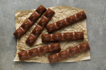 Tasty chocolate bars on grey table, top view