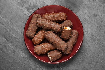 Plate with tasty chocolate bars on light grey table, top view