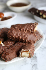 Tasty chocolate bars with caramel on white marble table, closeup