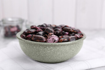 Bowl with dry kidney beans on table, closeup