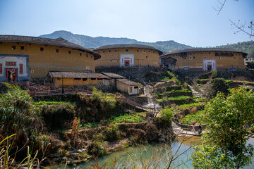 Obraz premium Yongding, Longyan, Fujian province, China - Mar 1st, 2021: The Fujian earthern buildings (also known as Hakka tulou) in mountains. These buildings are in Chuxi village.
