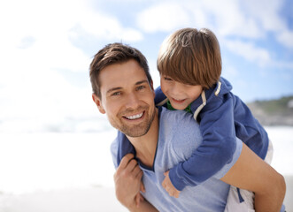 Father, child or family at beach for portrait, travel or holiday in summer with a smile for piggy back fun. A man and kid or son playing together on vacation at sea with a blue sky and happiness