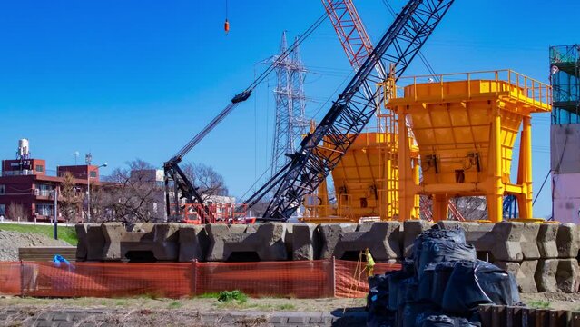 A timelapse of moving cranes at the under construction telephoto shot tilt