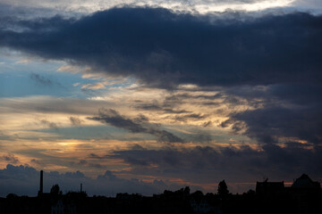 Dramatic sky with clouds on sunset over the city
