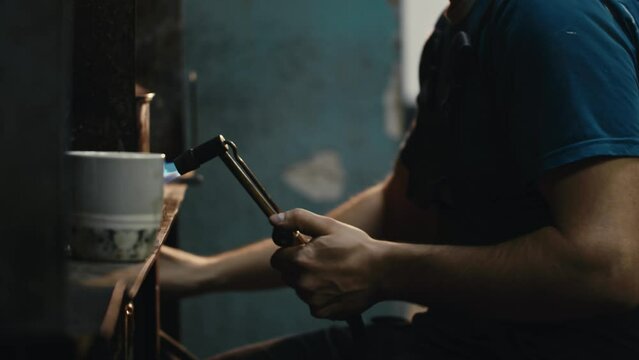 A male jeweler makes jewelry with a gas burner close-up
