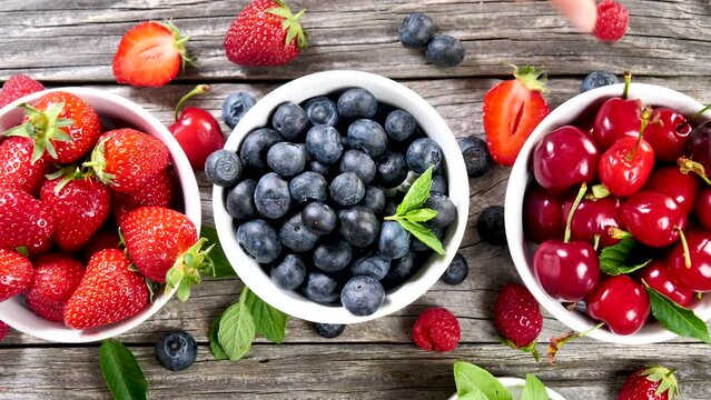 assorted of berries fruits- blueberry, cherry and strawberry- hand picking blueberry- summer, healthy eating concept