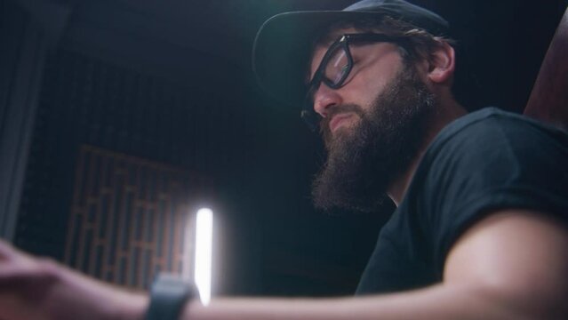 Stylish sound engineer, musician, producer uses MIDI controller or mixing board, plays on digital electric piano, creates new song. Work in sound recording studio. Music production concept. Close up.