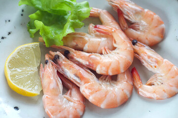 Shrimps with salad and lemon in a plate on the table. Overhead view